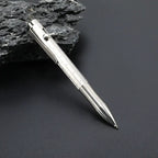 Bright silver titanium bolt action pen with the writing tip extended beside dark stone